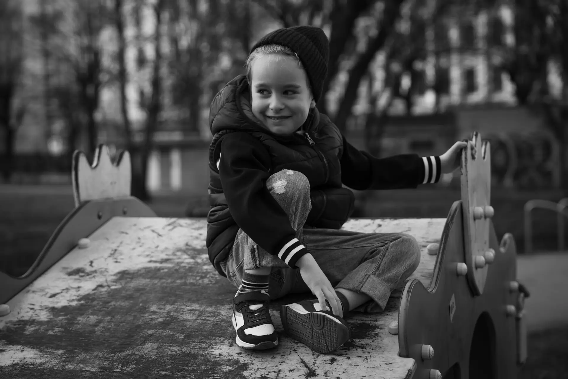 A black and white portrait photo of a small boy with a shallow depth of field