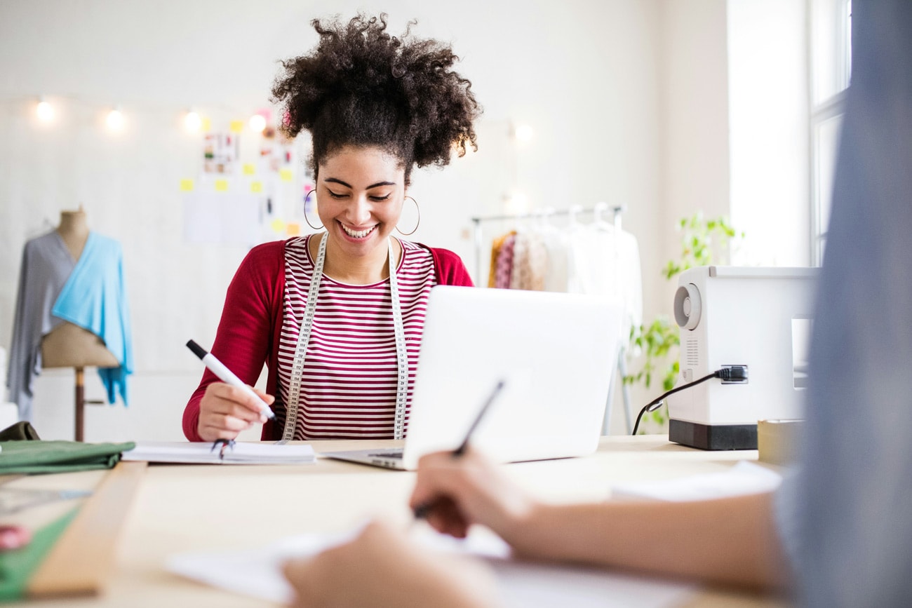 portrait photo of a woman working next to her computer