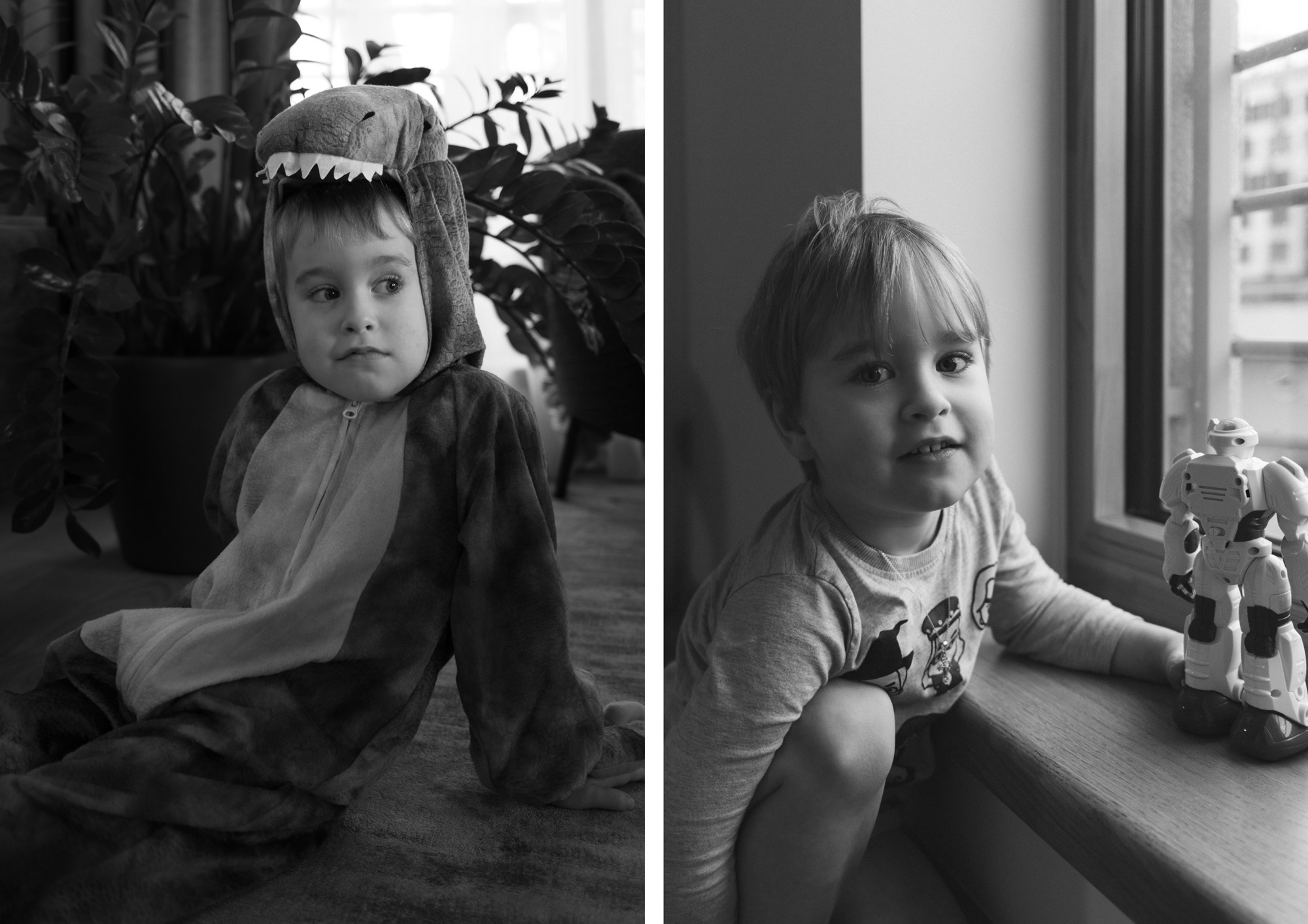 Child in dinosaur costume sitting indoors with natural side lighting, black and white family photography.